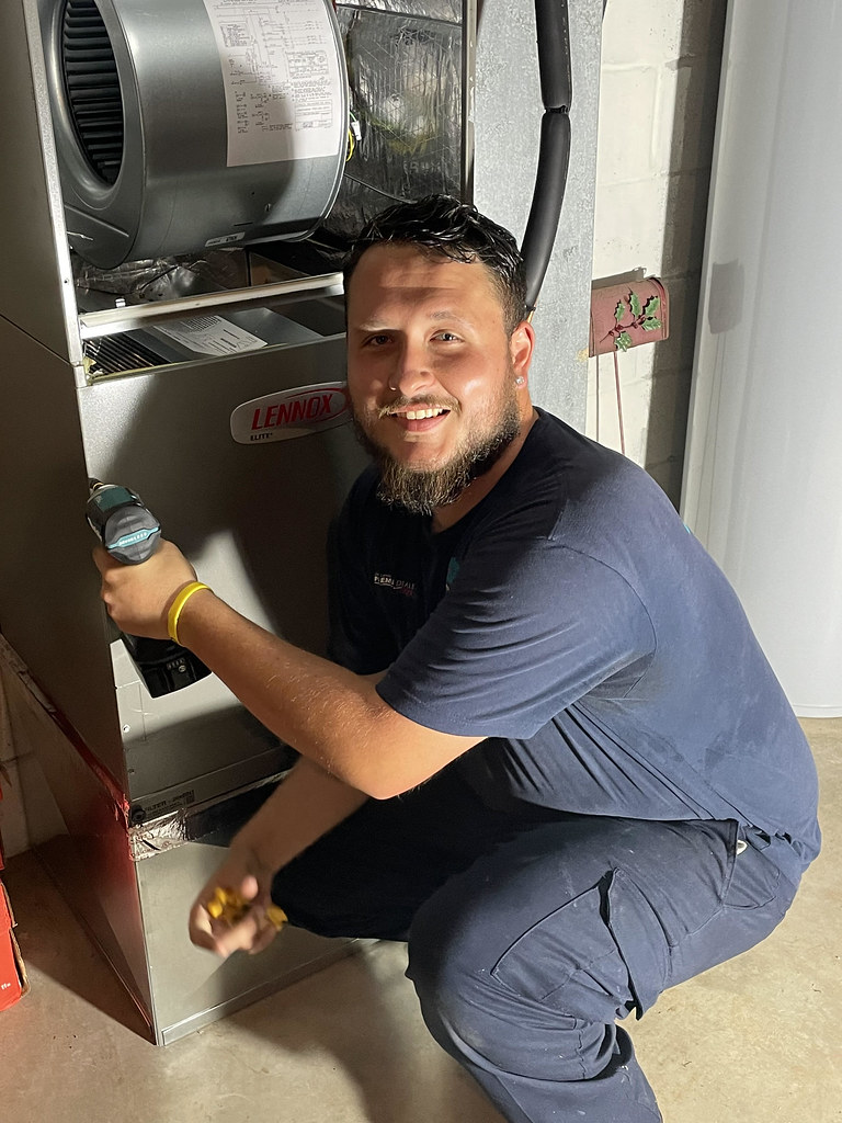 Technician installing an air handler for a heat pump system
